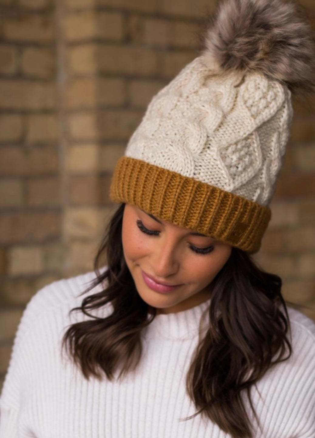 IVORY CABLE KNIT HAT WITH CAMEL CUFF AND FUR POM